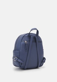 Zaino in pelle blu navy con un design strutturato. Presenta spallacci regolabili, una tasca frontale con zip e dettagli di cucitura discreti.