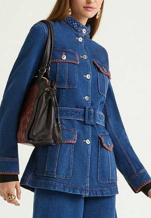 Denim jacket in dark blue with contrasting orange stitching. Features a high collar, multiple pockets, button closure, and belt.