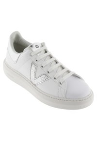 Baskets en cuir blanc avec un logo argenté texturé, lacets plats blancs et bout arrondi. Semelle en caoutchouc gris clair avec un branding discret.