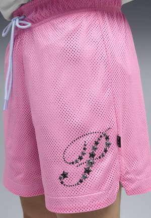 Pantalones cortos deportivos de malla rosa con cordón azul claro y patrón de estrellas negras en la parte inferior del lado frontal, llevados en la cadera y el muslo de una persona.