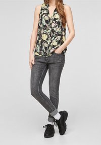 Květinový bezrukávový top v černé, žluté a zelené barvě. V kombinaci se šedými skinny džíny a černými teniskami. Měkká textura, volný střih.