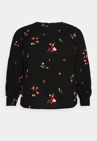 Sort langærmet bluse med små røde og hvide blomster mønstre og let puf ved ærmerne, som er samlet ved manchetterne.