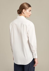 Witte longsleeve shirt met een klassieke kraag, achterkant met yoke en knoopmanchetten. Gladde stof met een iets relaxte pasvorm en een ronde zoom.