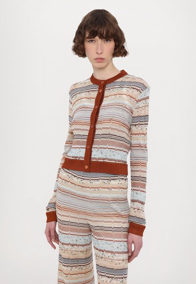Stickad cardigan med flerfärgade horisontella ränder, med en ribbad orange krage och knappstängning, tillsammans med matchande randiga byxor.
