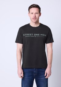 Czarna bawełniana koszulka z krótkim rękawem, z białym napisem "STREET ONE MEN ORIGINAL SUPPLY CO. WORN WITH PURPOSE" oraz okrągłym dekoltem.