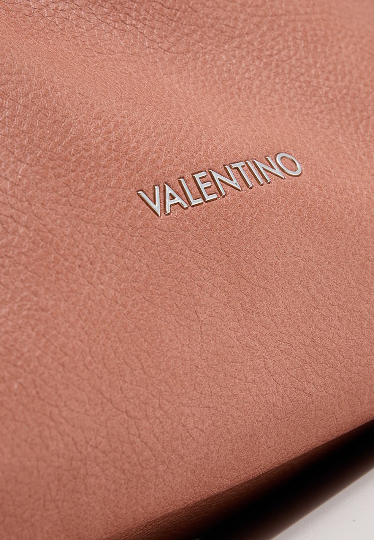Bolso de cuero color rosa con un acabado texturizado, que presenta un logo plateado "VALENTINO" en la parte frontal.