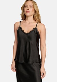 Schwarzes Satincamisole mit Spitzenbesatz entlang des Ausschnitts und der Träger, mit lockerem Schnitt und zartem Glanz, kombiniert mit einem passenden Rock.