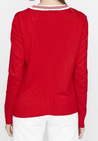 Suéter de punto rojo con mangas largas, que presenta un cuello de rayas blancas. Textura suave y un corte relajado con dobladillo acanalado.