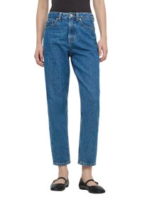 Jeansy z wysokim stanem, proste nogawki, niebieski denim z wyblakłą fakturą, design pięciu kieszeni oraz kontrastowe przeszycia. Kończą się lekko powyżej kostki.