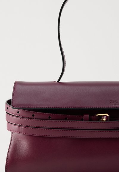 Σκούρα μωβ δερμάτινη τσάντα με κλείσιμο με καπάκι, λεπτό λουράκι και λεπτομέρεια ζώνης με μικρές τρύπες και πόρπη σε χρυσό τόνο.