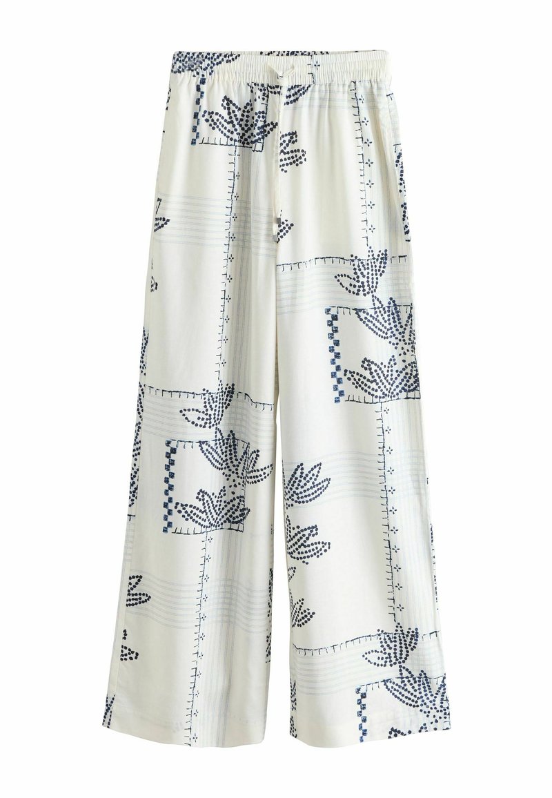 Pantalon blanc à jambes larges avec taille élastique, présentant un motif floral abstrait bleu et géométrique.