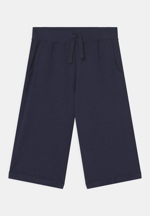 Shorts bleu marine longueur genou avec ceinture élastique, cordon de serrage à l'avant, poches latérales et ourlets repliés sur un fond uni.