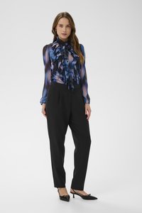 Blue and black ruffled blouse with a high collar, paired with black trousers. Ensemble complemented by pointed black heels.