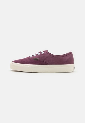 Zapatilla Vans de lona morada de corte bajo con cordones blancos y suela gruesa de goma blanca vista de lado.