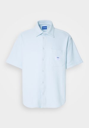 Kortermet lyseblå skjorte med knapper, teksturert stoff, krage, frontlomme med merke, og rett nederkant, egnet for uformell bruk.
