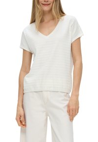 Witte textuur short-sleeve V-hals top met een relaxed fit, gecombineerd met lichte broeken. De stof heeft subtiele horizontale strepen.