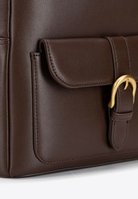 Borsa in pelle marrone con finitura testurizzata, dotata di tasca frontale, fibbia in metallo dorato e dettagli cuciti lungo i bordi.