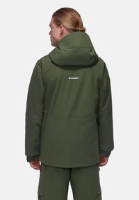 Giacca impermeabile verde con cappuccio, dotata di un logo sul retro, texture liscia e polsini regolabili per una vestibilità ottimale.