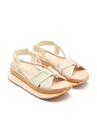 Sandalias de lona beige con correas cruzadas, un acento de cuerda texturizada y una suela en cuña blanca y naranja. Plantilla plana y diseño de espalda abierta.