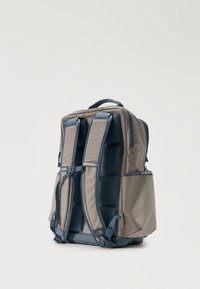 Γκρι και μπλε σακίδιο με επενδυμένους ιμάντες ώμου και πλαϊνές τσέπες, όρθιο σε απλό λευκό φόντο.