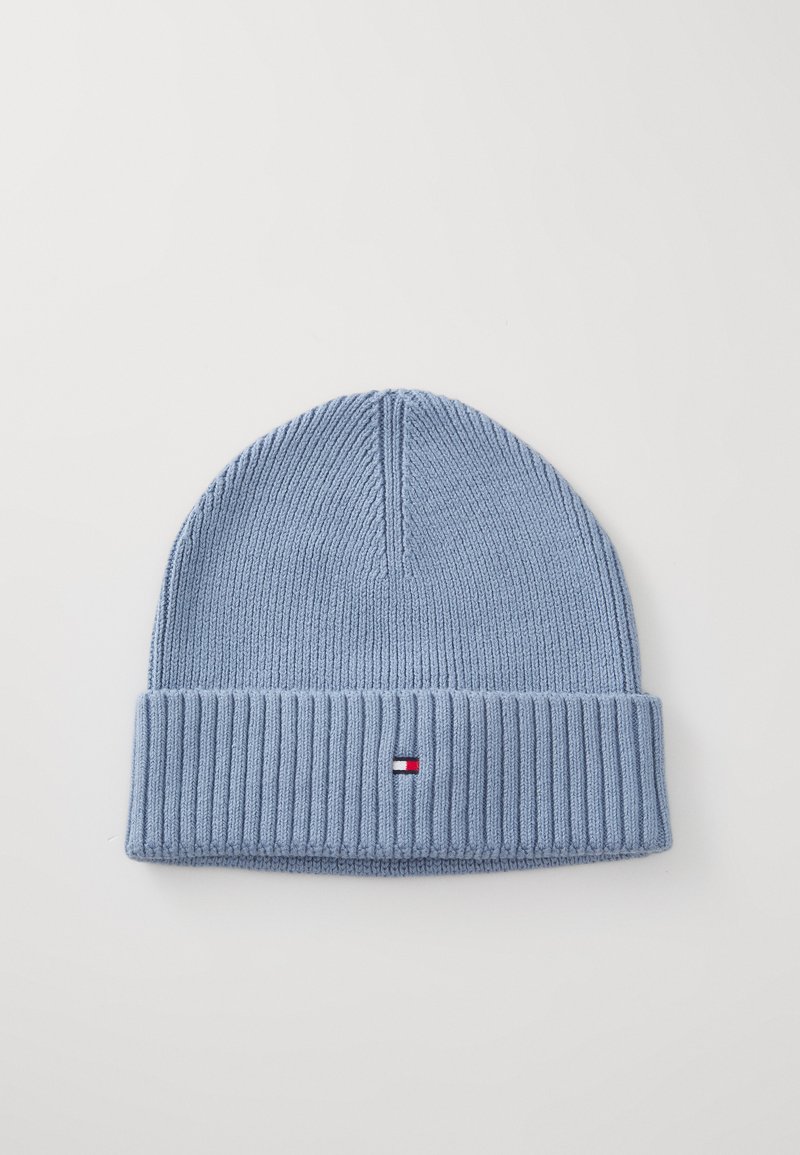 Lichtblauwe gebreide beanie met een omgevouwen ribbenmanchet en een klein rood, wit en blauw logo patch in het midden aan de voorkant.