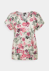 Kwiatowa bluzka z krótkim rękawem w jasnym beżu, z dekoltem w kształcie litery V. Projekt zawiera różowe i zielone wzory kwiatowe z czarnymi akcentami.