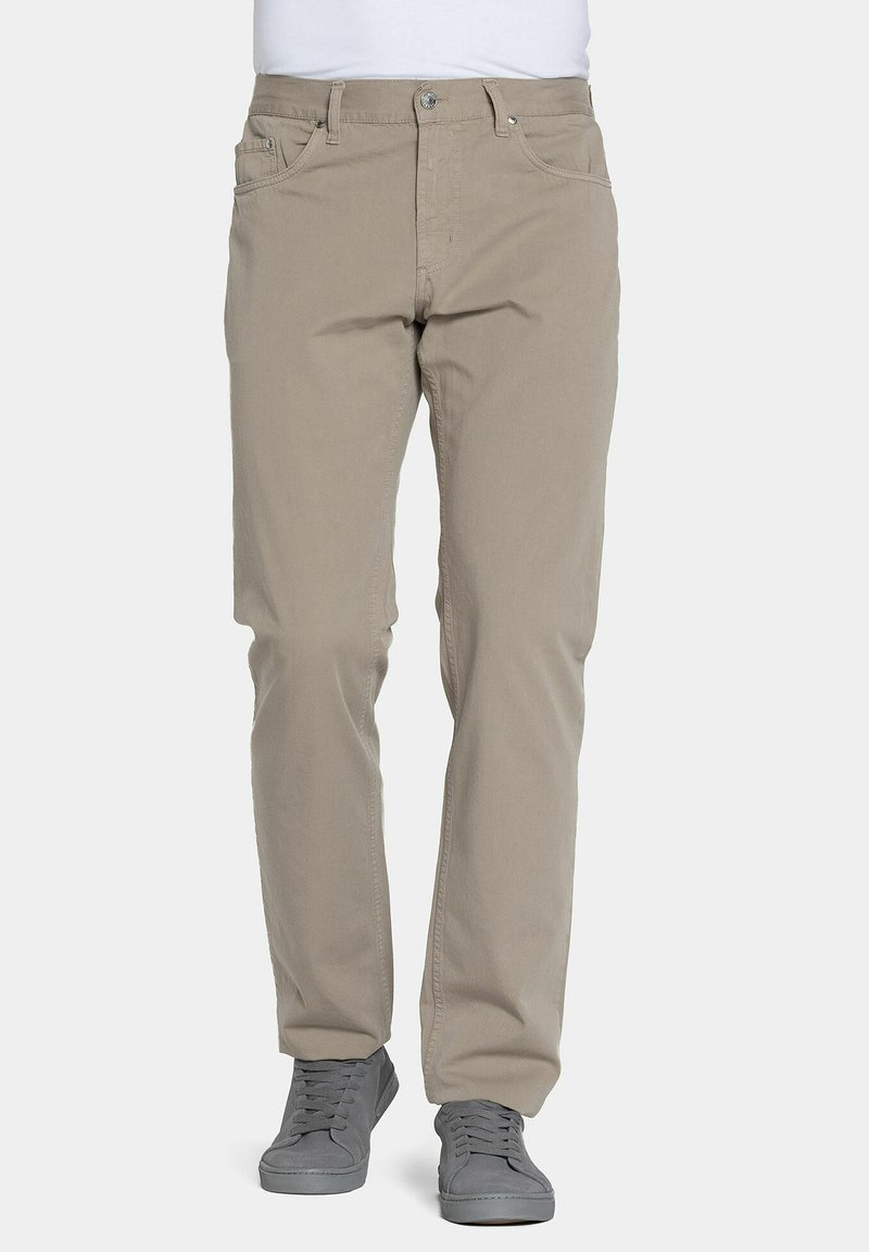 Pantaloni in cotone beige con gamba dritta, design a cinque tasche e chiusura con bottone metallico. Abbinati a scarpe sportive grigie.