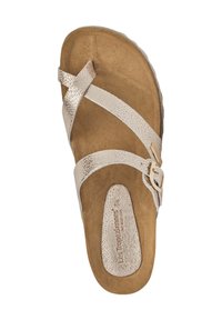 Sandales avec des brides croisées métalliques beige, semelle texturée et boucle ajustable. La semelle est plate avec une finition marron subtile.