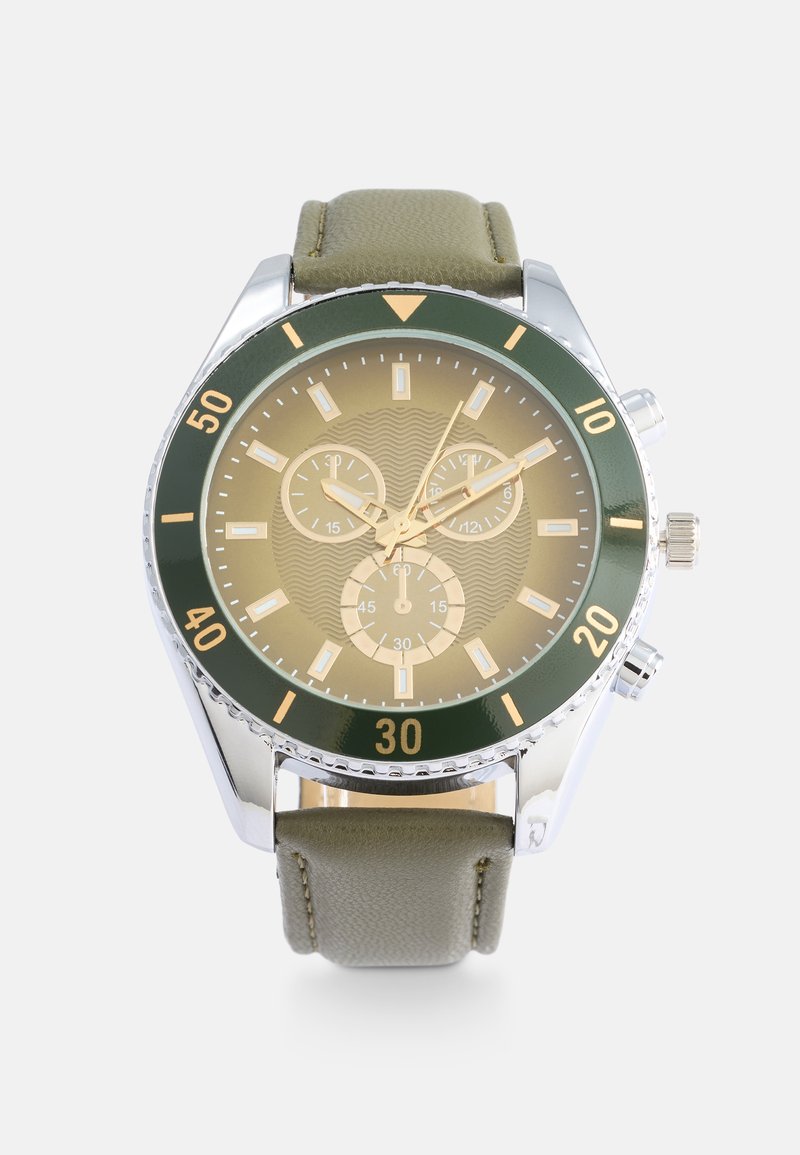Orologio con lunetta verde e cinturino in pelle khaki. Il quadrante circolare presenta uno sfondo texturizzato dorato e tre sottoquadranti. Accenti argentati mettono in risalto il design.