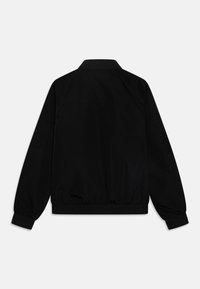 Must must jacket, mille kaelusega, pikad varrukad, elastsed mansetid ja ühtlane tekstuur. Ei ole nähtavaid logo ega dekoratiivelemente.