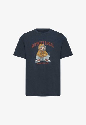 Navyblaue Baumwoll-T-Shirt mit einem zentralen Grafikdesign eines Faultiers in einem gelben Kapuzenpullover, mit dem Text "UNTERSTÜTZEN SIE DIE LOKALEN" und "STREET CATS" in Rot.