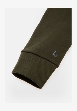 Mroczna oliwkowa zieleń rękaw bluzy z prążkowaną teksturą, z jasnoszarym logo w pobliżu mankietu. Gładki materiał z dopasowanym krojem.