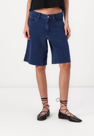Dark blue denim shorts with a relaxed fit, knee-length, featuring five pockets and a front button closure. Smooth texture, casual design.