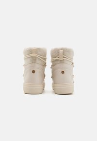 Beżowe skórzane botki za kostkę z miękkim szarym kołnierzem z fliśu, dekoracyjnym sznurkiem i okrągłym akcentem logo na pięcie. Teksturowana gumowa podeszwa.