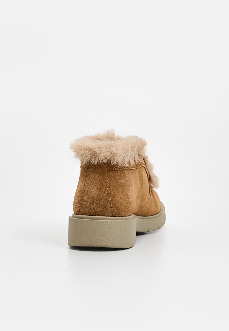Bottines en nubuck beige avec un col en fourrure, dotées d'une semelle en caoutchouc basse et d'une forme arrondie. Le design comprend des détails de couture.