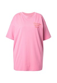 Rosa übergroßes Baumwoll-T-Shirt mit kurzen Ärmeln, das orangefarbene gestickte Schriftzüge und kleine dekorative Details an der Schulter aufweist.