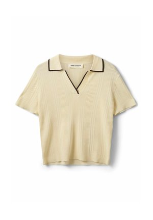 Maglia beige a maniche corte a coste con scollo a V, colletto e rifinitura scura lungo il bordo del colletto, etichettata Sofie Schnoor.