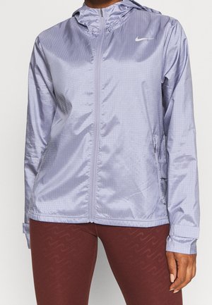 Hellviolette Kapuzenjacke mit Reißverschluss und dezentem Karomuster sowie weißem Nike-Logo auf der Brust, getragen mit dunkelroten Leggings.