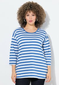 Blau-weißer gestreifter Langarm-T-Shirt mit Rundhalsausschnitt, lockerer Passform und weichem Material, kombiniert mit dunklen Jeans.