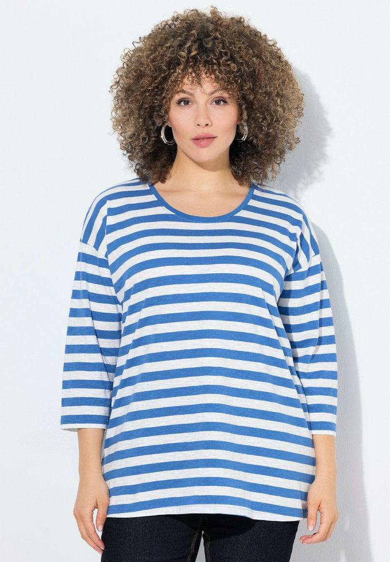 Blau-weißer gestreifter Langarm-T-Shirt mit Rundhalsausschnitt, lockerer Passform und weichem Material, kombiniert mit dunklen Jeans.