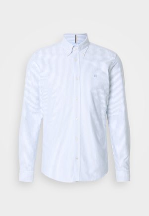 Modrá a biela pruhovaná dlhá košeľa s golierom, na hrudi má malé logo a zapínanie na gombíky. Vyrobené z bavlny.