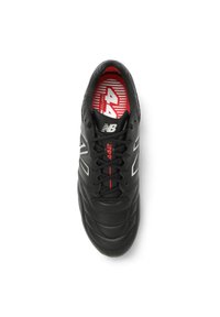 Black athletic shoe with a textured leather upper, lace-up design, and red accents on the interior and laces. Features gray logo and stripes.