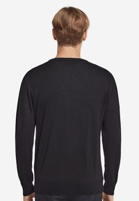 Svart långärmad tröja, rund halsringning, slät textur, medelhård tjocklek, figurnära design vid midja och ärmslut, minimal detaljering.