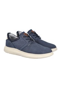 Deportivas de color azul marino con textura perforada, suela de goma crema en contraste y diseño con cordones. Presentan detalles en cuero marrón en la lengüeta.