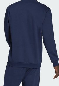 Sweat-shirt bleu marine à col rond, avec des poignets et un ourlet côtelés. Fabriqué en matériau doux, présentant une texture lisse sans motifs visibles.