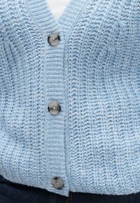 Cardigã de malha azul-claro com decote em V, tecido texturizado, acabamentos canelados e cinco grandes botões cinzentos na parte da frente.