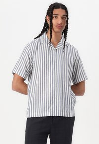 Korte mouw shirt van lichtgewicht stof, met verticale blauw-witte strepen, een puntkraag en knoopsluiting aan de voorkant.