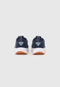 Jūras tumši zili sporta apavi ar sietu augšdaļu, balto vidusdaļu un oranžu gumijas zoli. Iekļauts vilkšanas cilpa un logo detaļa uz papēža.