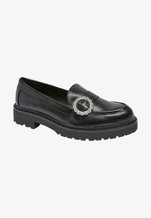 Mocassins en cuir noir à bout rond, ornés d'un accent circulaire en gemme décorative et d'une semelle épaisse et texturée noire.