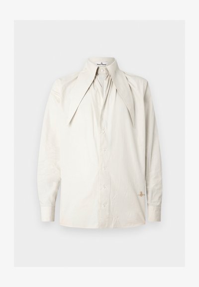 Gaiši bēša garām piedurknēm krekls ar lielu, salocītu apkakli un pogu aizdari priekšpusē. Tam ir smalks tekstūras raksts un neliela izšūta detaļa malu apakšdaļā.